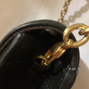 The lip mini bag with a gold tone chain that has hooks to attach to bag